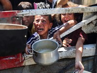 Palestinians wait to receive food from a charity kitchen, amid a hunger crisis, in Gaza City, July 23, 2025. REUTERS/Mahmoud Issa