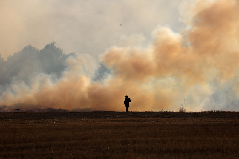 Seseorang berdiri di tengah asap saat kebakaran hutan melanda sebuah desa di Dubrava, Kosovo, 22 Juli 2025. Seseorang berdiri di tengah asap saat kebakaran hutan melanda sebuah desa di Dubrava, Kosovo, 22 Juli 2025. (REUTERS/Valdrin Xhemaj)