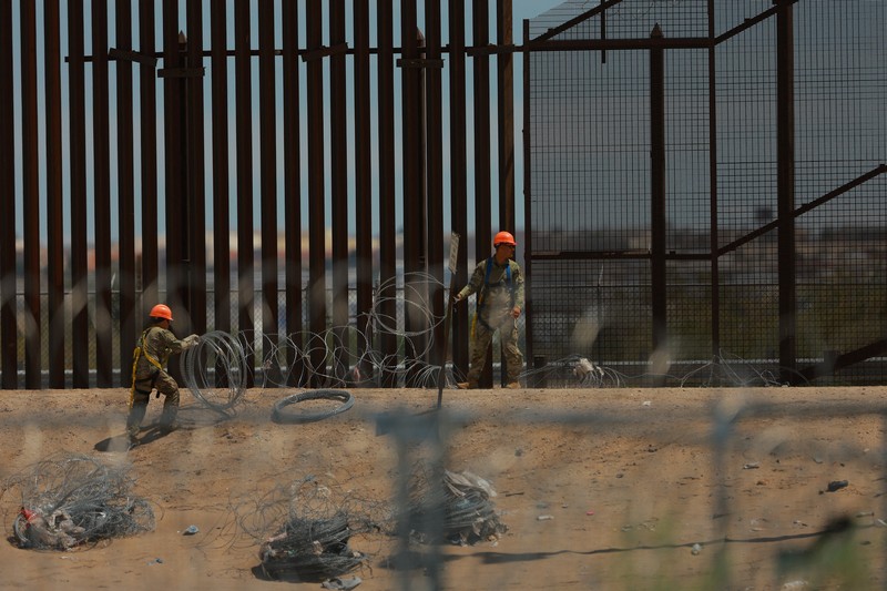 Insinyur tempur Angkatan Darat AS memasang kawat berduri di tembok perbatasan AS-Meksiko untuk memperkuat keamanan di El Paso Texas, seperti yang terlihat dari Ciudad Juarez, Meksiko, 23 Juli 2025. (REUTERS/Jose Luis Gonzalez)