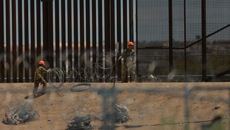 Insinyur tempur Angkatan Darat AS memasang kawat berduri di tembok perbatasan AS-Meksiko untuk memperkuat keamanan di El Paso Texas, seperti yang terlihat dari Ciudad Juarez, Meksiko, 23 Juli 2025. (REUTERS/Jose Luis Gonzalez)