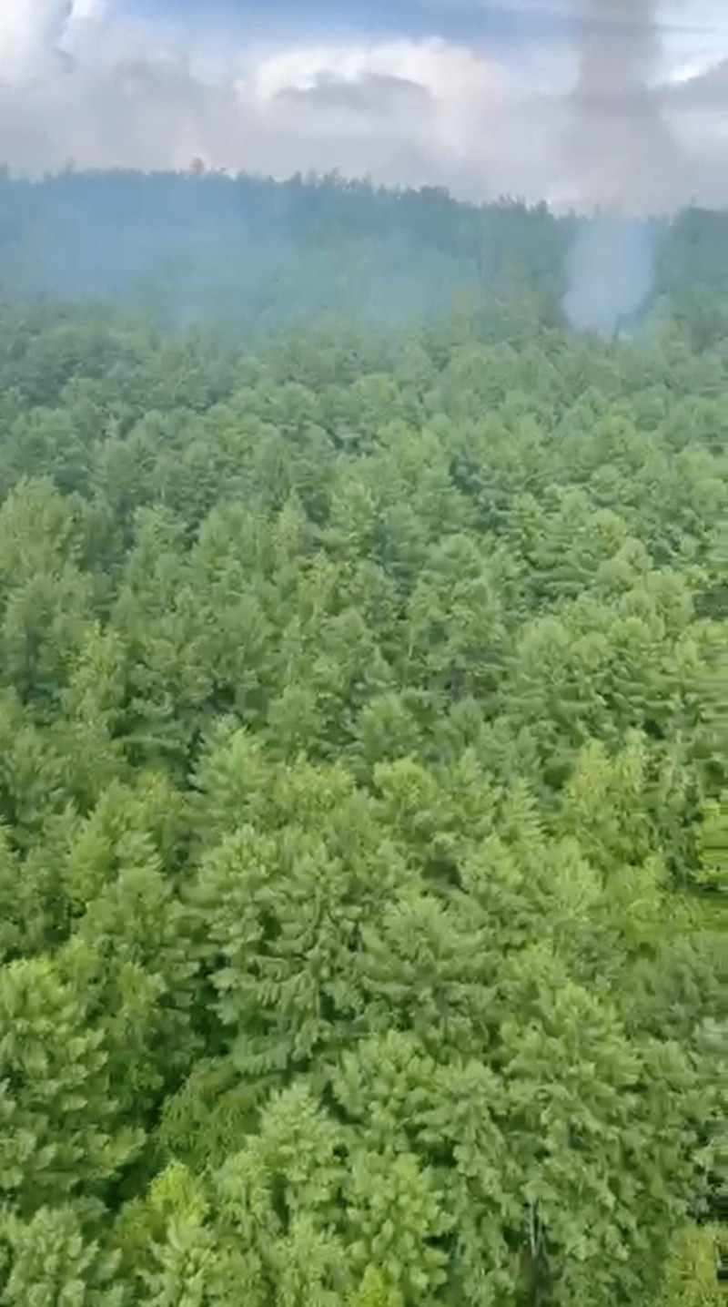 RUSSIA-AIRPLANE/CRASH SITE Smoke rises at the crash site of an Angara Airlines An-24 passenger plane near Tynda in the Amur Region, Russia July 24, 2025, in this still image taken from video. Federal Air Transport Agency/Handout via REUTERS ATTENTION EDITORS - THIS IMAGE HAS BEEN SUPPLIED BY A THIRD PARTY. NO RESALES. NO ARCHIVES. MANDATORY CREDIT.