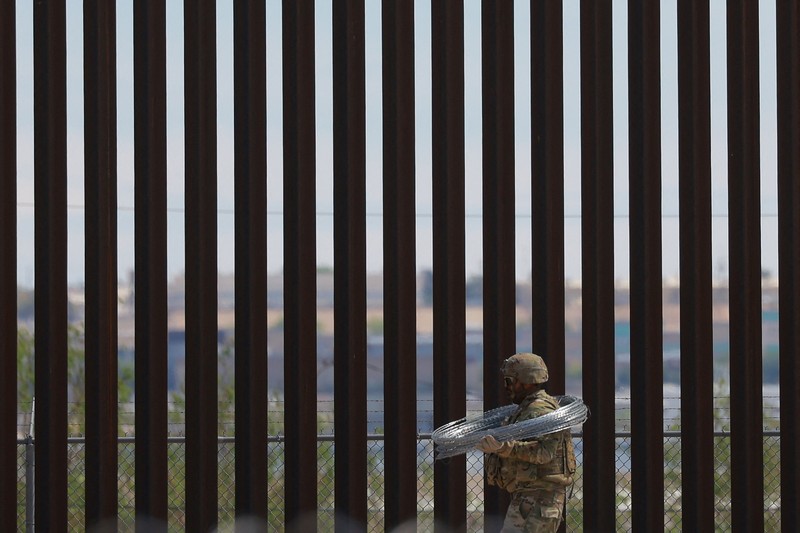Insinyur tempur Angkatan Darat AS memasang kawat berduri di tembok perbatasan AS-Meksiko untuk memperkuat keamanan di El Paso Texas, seperti yang terlihat dari Ciudad Juarez, Meksiko, 23 Juli 2025. (REUTERS/Jose Luis Gonzalez)