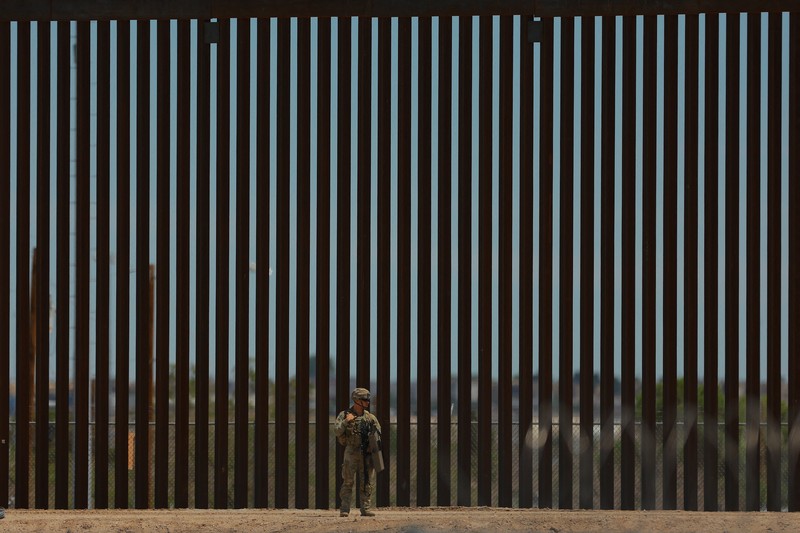 Insinyur tempur Angkatan Darat AS memasang kawat berduri di tembok perbatasan AS-Meksiko untuk memperkuat keamanan di El Paso Texas, seperti yang terlihat dari Ciudad Juarez, Meksiko, 23 Juli 2025. (REUTERS/Jose Luis Gonzalez)