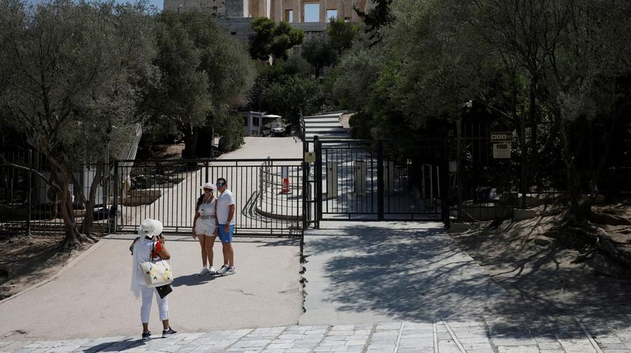 Orang-orang berjalan di depan kuil Erechtheion di puncak bukit Acropolis saat gelombang panas melanda dengan suhu diperkirakan mencapai 40 derajat Celsius, di Athena, Yunani, 24 Juli 2025. (REUTERS/Louiza Vradi)