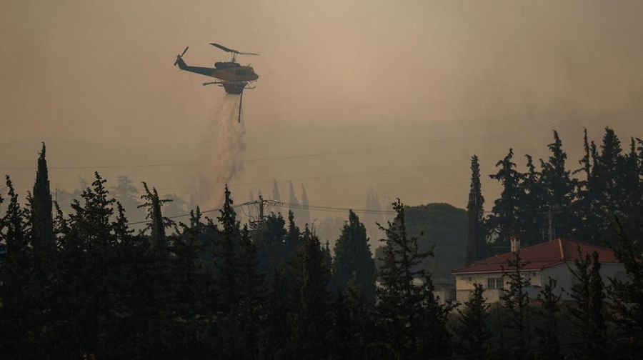Helikopter pemadam kebakaran melakukan penyemprotan air saat kebakaran hutan melanda desa Drosopigi, dekat Athena, Yunani, 26 Juli 2025. (REUTERS/Alkis Konstantinidis)