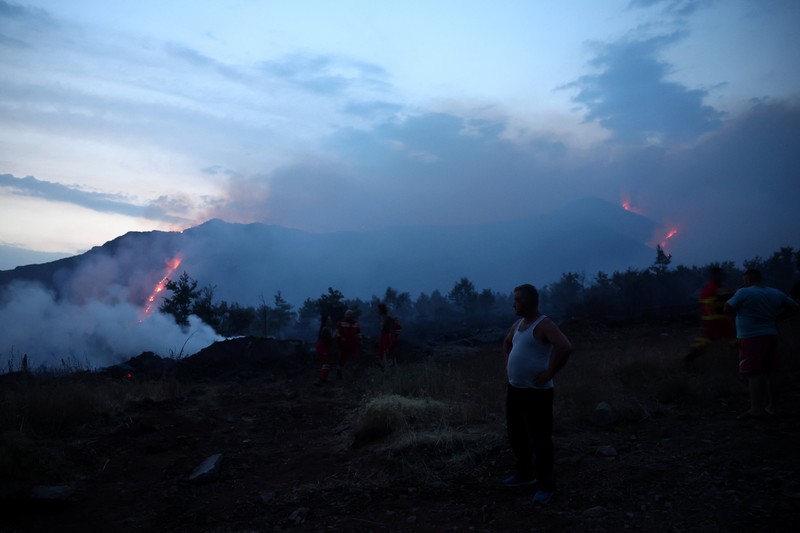 Seorang anggota layanan darurat berdiri di samping kebakaran hutan di dekat Bulqiza, Albania, Sabtu (26/7/2025). (REUTERS/Florion Goga) Seorang anggota layanan darurat berdiri di samping kebakaran hutan di dekat Bulqiza, Albania, Sabtu (26/7/2025). (REUTERS/Florion Goga)