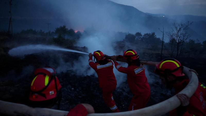Anggota layanan darurat bekerja untuk memadamkan kebakaran hutan di Kalas, Delvina, Albania, 27 Juli 2025. (REUTERS/Florion Goga)
