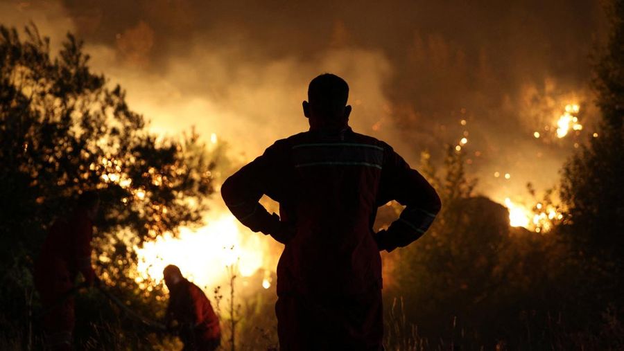 Anggota layanan darurat bekerja untuk memadamkan kebakaran hutan di Kalas, Delvina, Albania, 27 Juli 2025. (REUTERS/Florion Goga)
