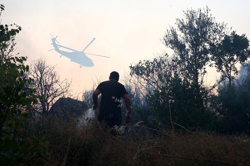 Anggota layanan darurat bekerja untuk memadamkan kebakaran hutan di Kalas, Delvina, Albania, 27 Juli 2025. Anggota layanan darurat bekerja untuk memadamkan kebakaran hutan di Kalas, Delvina, Albania, 27 Juli 2025. (REUTERS/Florion Goga)