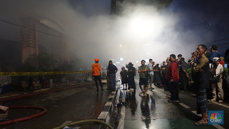 Kobaran api dan asap masih terlihat di Pasar Taman Puring, Kebayoran Baru, Jakarta Selatan, Senin (28/7/2025). Petugas Damkar masih berusaha memadamkan si jago merah. (CNBC Indonesia/Muhammad Sabki)