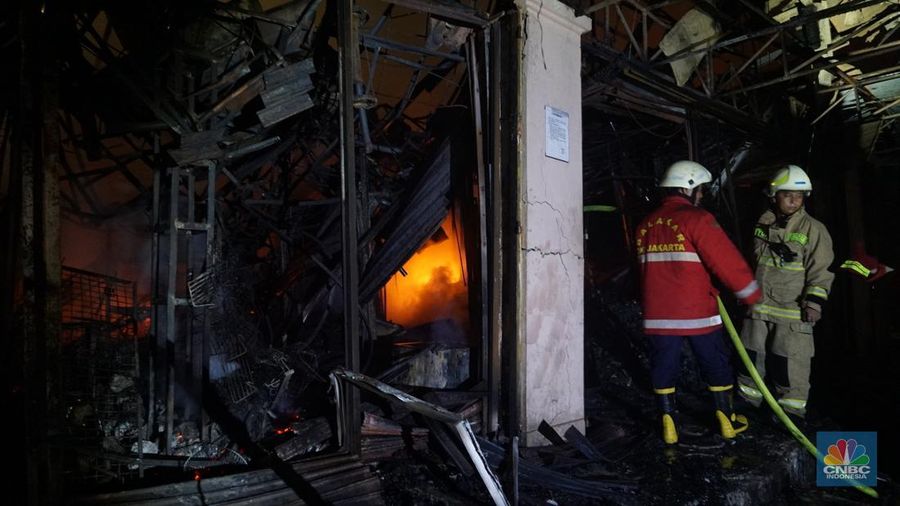 Kobaran api dan asap masih terlihat di Pasar Taman Puring, Kebayoran Baru, Jakarta Selatan, Senin (28/7/2025). Petugas Damkar masih berusaha memadamkan si jago merah. (CNBC Indonesia/Muhammad Sabki)
