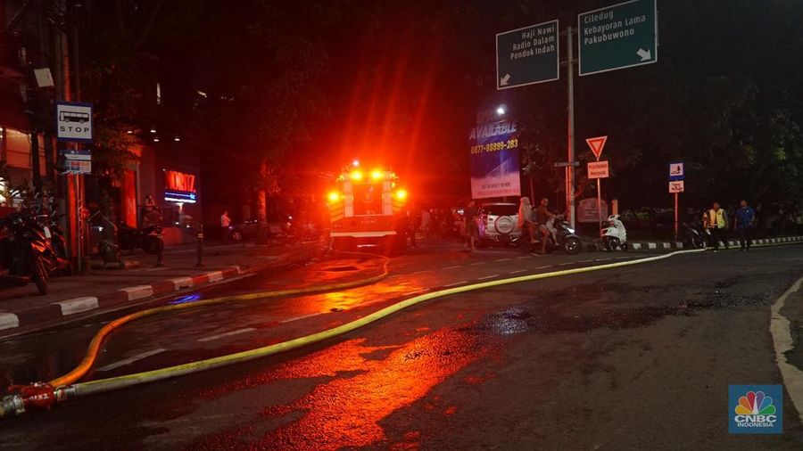 Kobaran api dan asap masih terlihat di Pasar Taman Puring, Kebayoran Baru, Jakarta Selatan, Senin (28/7/2025). Petugas Damkar masih berusaha memadamkan si jago merah. (CNBC Indonesia/Muhammad Sabki)