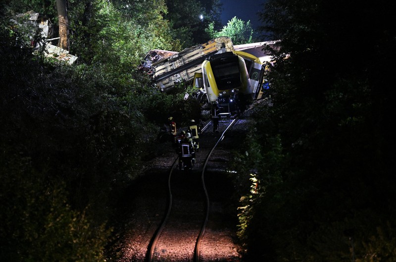 Petugas darurat bekerja di lokasi kereta lokal tergelincir yang menyebabkan kematian beberapa penumpang, di Riedlingen dekat Biberach, Jerman, 27 Juli 2025. (REUTERS/Markus Ulmer)