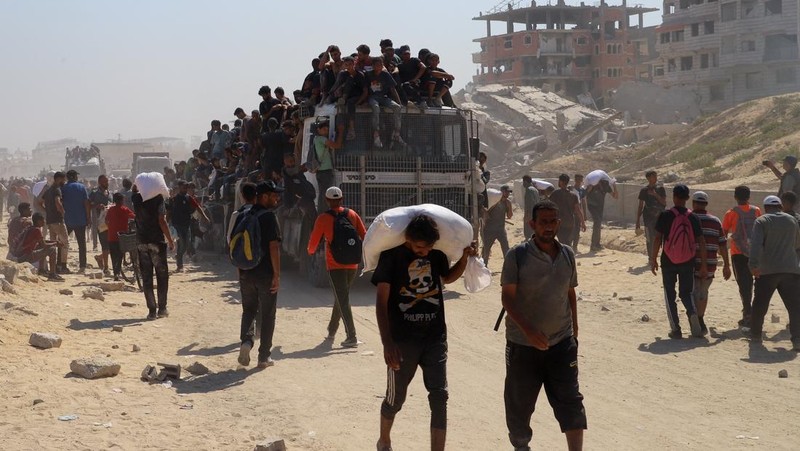 Warga Palestina berkumpul saat mencari bantuan yang masuk ke Gaza melalui Israel, di Beit Lahia, Jalur Gaza utara, 27 Juli 2025. (REUTERS/Mahmoud Issa)