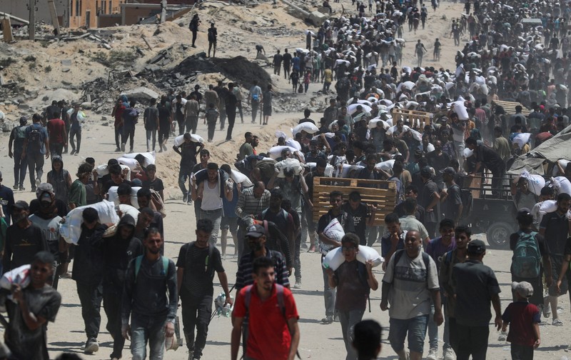 Warga Palestina berkumpul saat mencari bantuan yang masuk ke Gaza melalui Israel, di Beit Lahia, Jalur Gaza utara, 27 Juli 2025. (REUTERS/Mahmoud Issa)