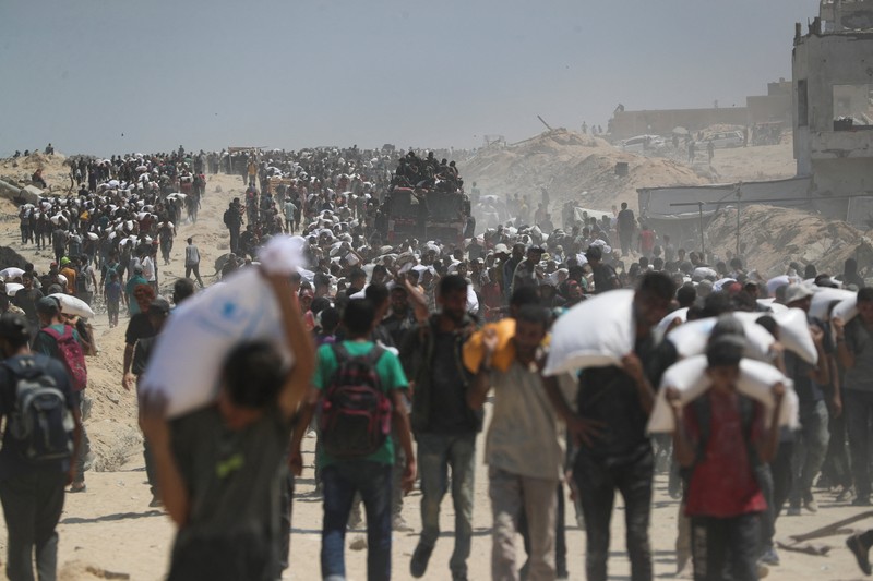 Warga Palestina berkumpul saat mencari bantuan yang masuk ke Gaza melalui Israel, di Beit Lahia, Jalur Gaza utara, 27 Juli 2025. (REUTERS/Mahmoud Issa)