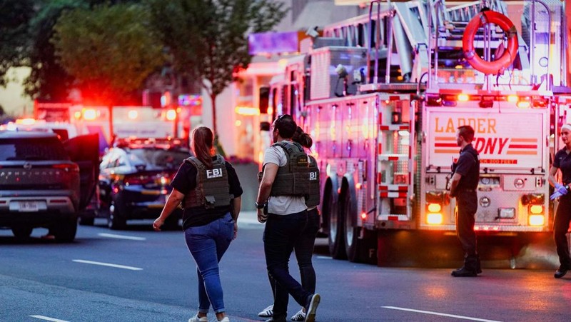Anggota media berjalan melewati kendaraan layanan darurat di dekat lokasi kejadian penembakan yang dilaporkan di wilayah Manhattan, New York City, AS, 28 Juli 2025. (REUTERS/Bing Guan)