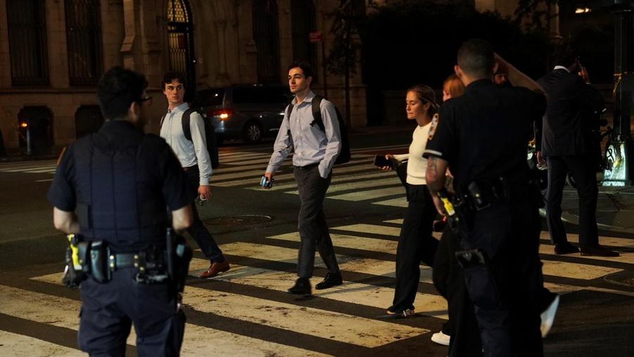 Anggota media berjalan melewati kendaraan layanan darurat di dekat lokasi kejadian penembakan yang dilaporkan di wilayah Manhattan, New York City, AS, 28 Juli 2025. (REUTERS/Bing Guan)