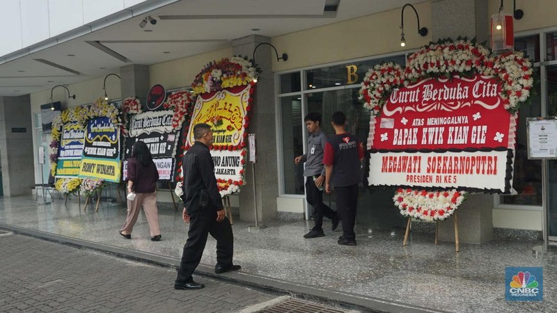 Pekerja membawa karangan bunga di Rumah Duka Sentosa tempat mantan Menteri Koordinator Bidang Perekonomian, Kwik Kian Gie disemayamkan, RSPAD Gatot Subroto, Jakarta Pusat, Selasa (29/7/2025). (CNBC Indonesia/Muhammad Sabki)