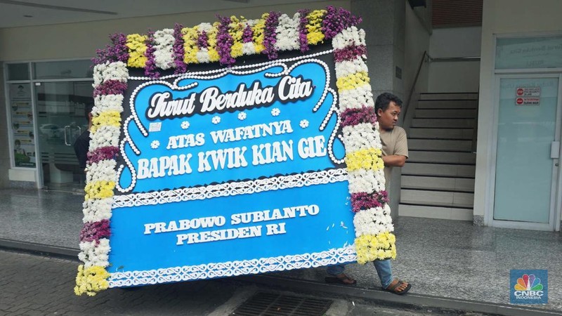 Pekerja membawa karangan bunga di Rumah Duka Sentosa tempat mantan Menteri Koordinator Bidang Perekonomian, Kwik Kian Gie disemayamkan, RSPAD Gatot Subroto, Jakarta Pusat, Selasa (29/7/2025). (CNBC Indonesia/Muhammad Sabki)