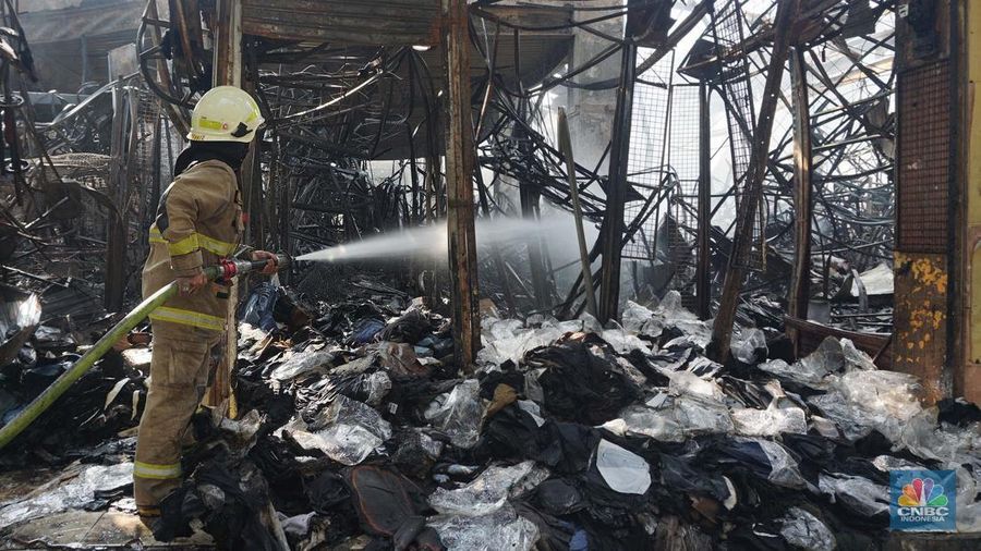 Petugas pemadam kebakaran memadamkan sisa api kebakaran Pasar Taman Puring, Kebayoran Baru, Jakarta, Selasa, (29/7/2025). (CNBC Indonesia/Muhammad Sabki)