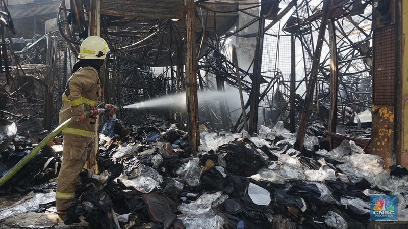 Petugas pemadam kebakaran memadamkan sisa api kebakaran Pasar Taman Puring, Kebayoran Baru, Jakarta, Selasa, (29/7/2025). (CNBC Indonesia/Muhammad Sabki)