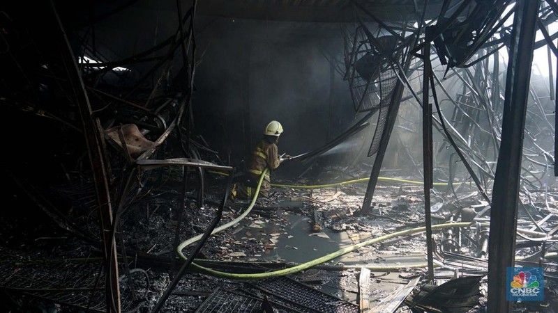 Petugas pemadam kebakaran memadamkan sisa api kebakaran Pasar Taman Puring, Kebayoran Baru, Jakarta, Selasa, (29/7/2025). (CNBC Indonesia/Muhammad Sabki)