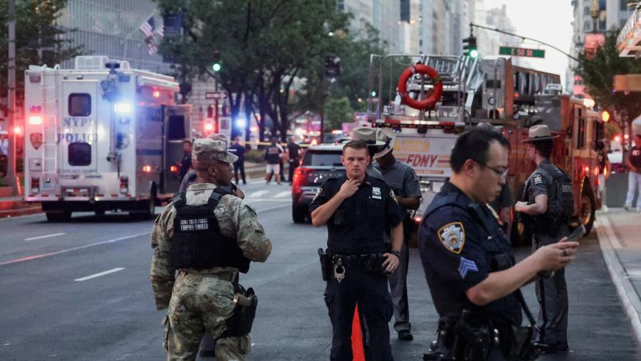 Anggota media berjalan melewati kendaraan layanan darurat di dekat lokasi kejadian penembakan yang dilaporkan di wilayah Manhattan, New York City, AS, 28 Juli 2025. (REUTERS/Bing Guan)