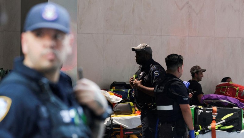 Anggota media berjalan melewati kendaraan layanan darurat di dekat lokasi kejadian penembakan yang dilaporkan di wilayah Manhattan, New York City, AS, 28 Juli 2025. (REUTERS/Bing Guan)