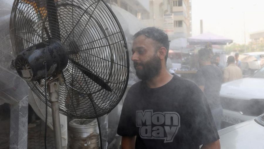 Seorang pria mendinginkan wajahnya dengan kabut air dari alat penyiram selama gelombang panas di Baghdad, Irak, 28 Juli 2025. (REUTERS/Ahmed Saad)