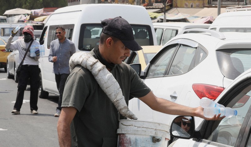 Seorang pria mendinginkan wajahnya dengan kabut air dari alat penyiram selama gelombang panas di Baghdad, Irak, 28 Juli 2025. Seorang pria mendinginkan wajahnya dengan kabut air dari alat penyiram selama gelombang panas di Baghdad, Irak, 28 Juli 2025. (REUTERS/Ahmed Saad)