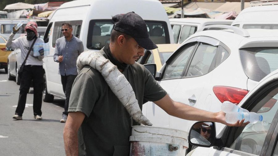 Seorang pria mendinginkan wajahnya dengan kabut air dari alat penyiram selama gelombang panas di Baghdad, Irak, 28 Juli 2025. (REUTERS/Ahmed Saad)