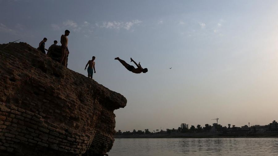 Seorang pria mendinginkan wajahnya dengan kabut air dari alat penyiram selama gelombang panas di Baghdad, Irak, 28 Juli 2025. (REUTERS/Ahmed Saad)