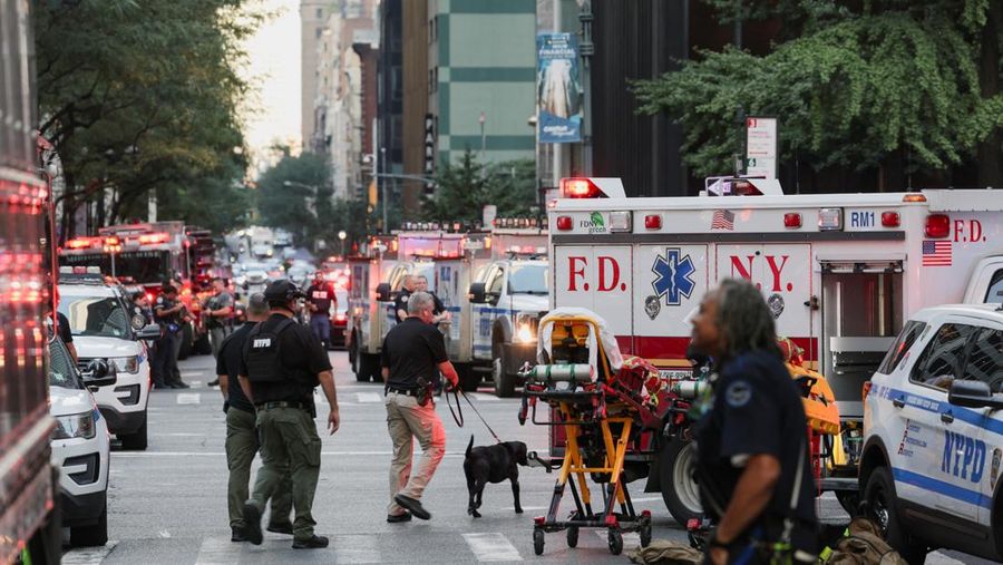 Anggota media berjalan melewati kendaraan layanan darurat di dekat lokasi kejadian penembakan yang dilaporkan di wilayah Manhattan, New York City, AS, 28 Juli 2025. (REUTERS/Bing Guan)