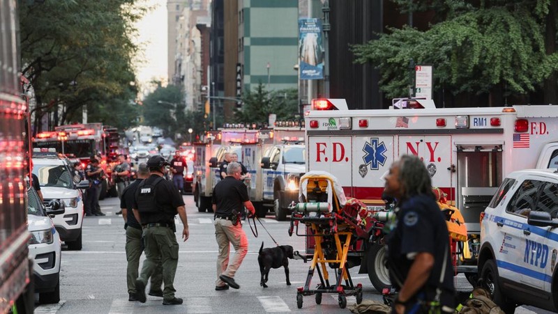 Anggota media berjalan melewati kendaraan layanan darurat di dekat lokasi kejadian penembakan yang dilaporkan di wilayah Manhattan, New York City, AS, 28 Juli 2025. (REUTERS/Bing Guan)