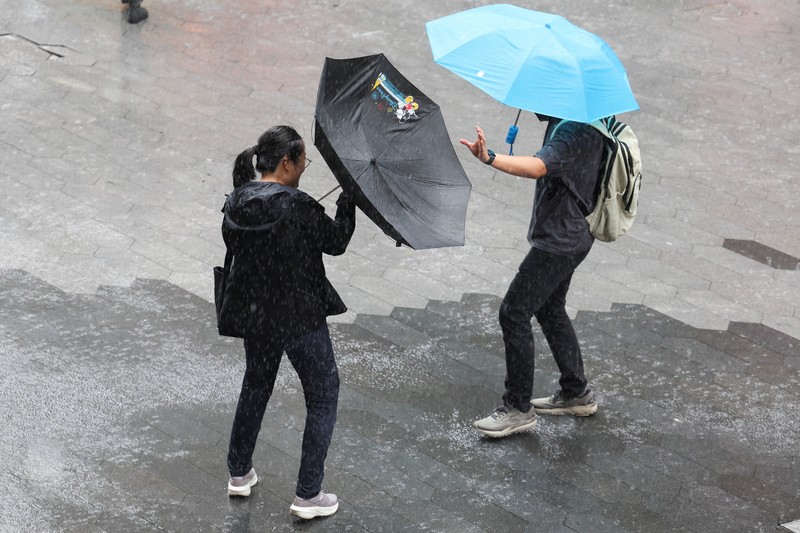 Orang-orang mencoba memperbaiki payung yang tertiup angin saat berjalan di jalan saat hujan deras dan angin kencang, setelah Badai Tropis Co-May mendarat di kota terdekat, di Shanghai, CHina, Rabu (30/7/2025). (REUTERS/Go Nakamura) Orang-orang mencoba memperbaiki payung yang tertiup angin saat berjalan di jalan saat hujan deras dan angin kencang, setelah Badai Tropis Co-May mendarat di kota terdekat, di Shanghai, CHina, Rabu (30/7/2025). (REUTERS/Go Nakamura)