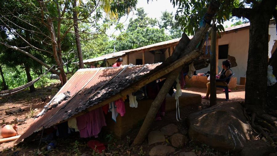 Seorang wanita dan seorang anak berjalan di samping puing-puing bangunan yang rusak setelah gempa bumi, di Comapa, Jutiapa, Guatemala, 30 Juli 2025. (REUTERS/Cristina Chiquin)