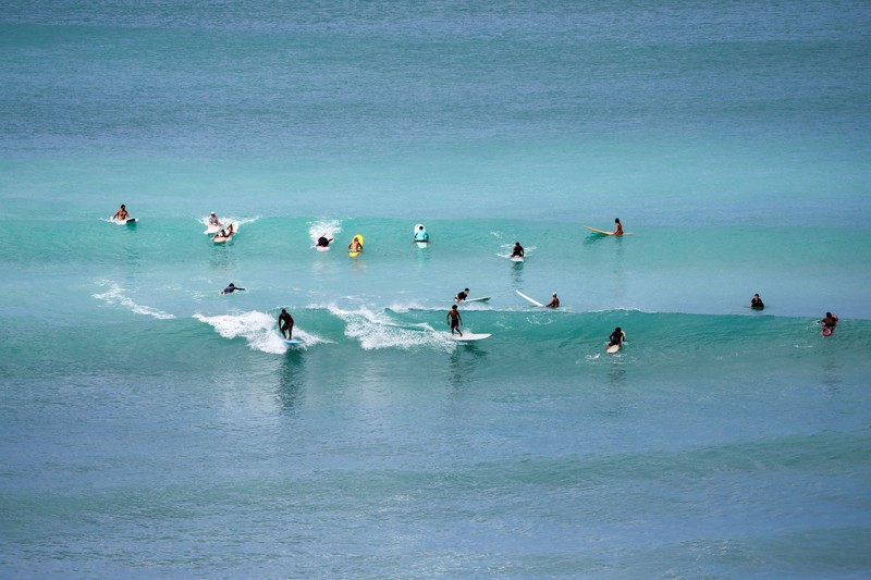 Saat sepasang kekasih berjalan di pantai, ombak menghantam Pantai Waikiki setelah pihak berwenang menurunkan peringatan tsunami sebelumnya menyusul gempa bumi di Semenanjung Kamchatka Timur Jauh Rusia, di Honolulu, Hawaii, AS, 30 Juli 2025. (REUTERS/Marco Garcia)