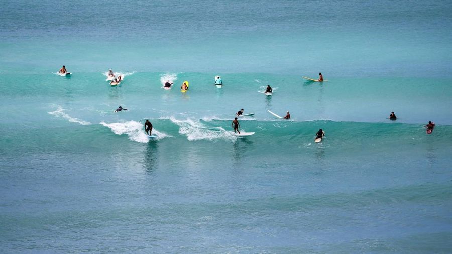 Saat sepasang kekasih berjalan di pantai, ombak menghantam Pantai Waikiki setelah pihak berwenang menurunkan peringatan tsunami sebelumnya menyusul gempa bumi di Semenanjung Kamchatka Timur Jauh Rusia, di Honolulu, Hawaii, AS, 30 Juli 2025. (REUTERS/Marco Garcia)