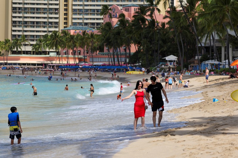 Saat sepasang kekasih berjalan di pantai, ombak menghantam Pantai Waikiki setelah pihak berwenang menurunkan peringatan tsunami sebelumnya menyusul gempa bumi di Semenanjung Kamchatka Timur Jauh Rusia, di Honolulu, Hawaii, AS, 30 Juli 2025. (REUTERS/Marco Garcia)