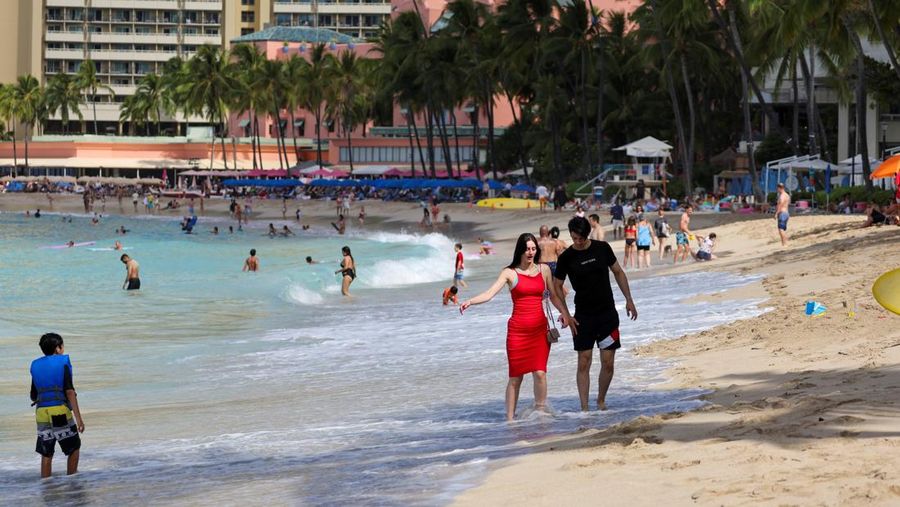 Saat sepasang kekasih berjalan di pantai, ombak menghantam Pantai Waikiki setelah pihak berwenang menurunkan peringatan tsunami sebelumnya menyusul gempa bumi di Semenanjung Kamchatka Timur Jauh Rusia, di Honolulu, Hawaii, AS, 30 Juli 2025. (REUTERS/Marco Garcia)