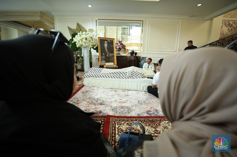 Petugas menata karangan bunga di kediaman almarhum Suryadharma Ali di Jl. Cipinang Cempedak I No.30, Cipinang Cempedak, Kecamatan Jatinegara, Kota Jakarta Timur, Kamis (31/7/2025). (CNBC Indonesia/Tri Susilo)
