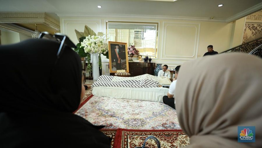 Petugas menata karangan bunga di kediaman almarhum Suryadharma Ali di Jl. Cipinang Cempedak I No.30, Cipinang Cempedak, Kecamatan Jatinegara, Kota Jakarta Timur, Kamis (31/7/2025). (CNBC Indonesia/Tri Susilo)