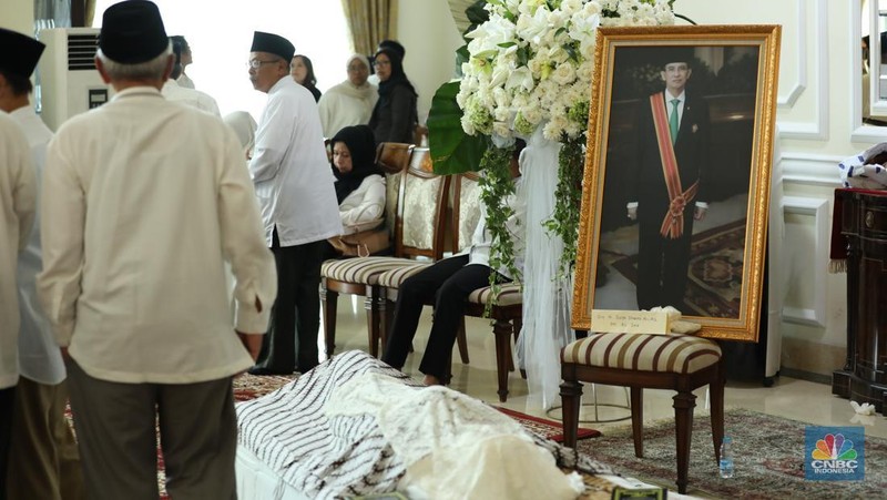 Petugas menata karangan bunga di kediaman almarhum Suryadharma Ali di Jl. Cipinang Cempedak I No.30, Cipinang Cempedak, Kecamatan Jatinegara, Kota Jakarta Timur, Kamis (31/7/2025). (CNBC Indonesia/Tri Susilo)