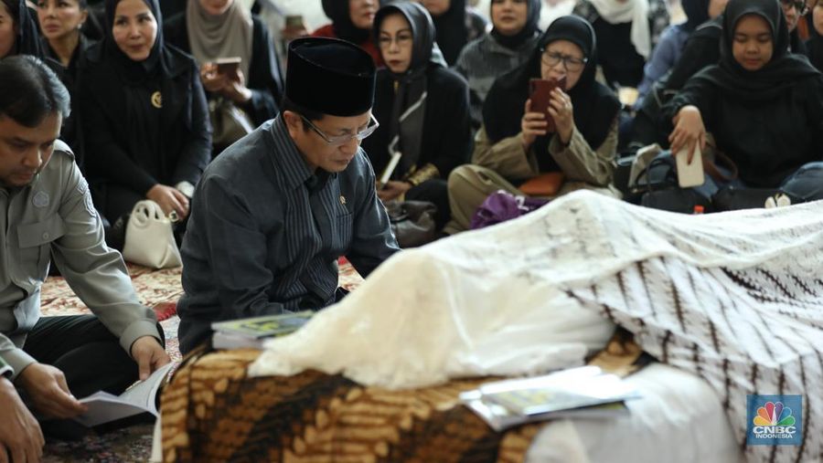 Petugas menata karangan bunga di kediaman almarhum Suryadharma Ali di Jl. Cipinang Cempedak I No.30, Cipinang Cempedak, Kecamatan Jatinegara, Kota Jakarta Timur, Kamis (31/7/2025). (CNBC Indonesia/Tri Susilo)