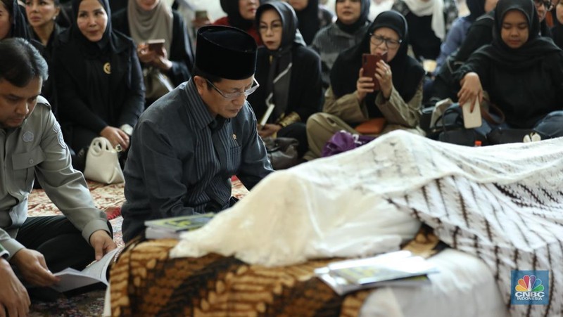 Petugas menata karangan bunga di kediaman almarhum Suryadharma Ali di Jl. Cipinang Cempedak I No.30, Cipinang Cempedak, Kecamatan Jatinegara, Kota Jakarta Timur, Kamis (31/7/2025). (CNBC Indonesia/Tri Susilo)