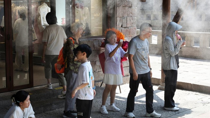 Seorang anak membilas wajahnya dengan air dari pancuran untuk menyejukkan diri di tengah peringatan bahaya panas di Chongqing, Tiongkok, 31 Juli 2025. (REUTERS/Go Nakamura)