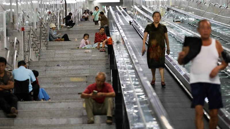 Seorang anak membilas wajahnya dengan air dari pancuran untuk menyejukkan diri di tengah peringatan bahaya panas di Chongqing, Tiongkok, 31 Juli 2025. (REUTERS/Go Nakamura)