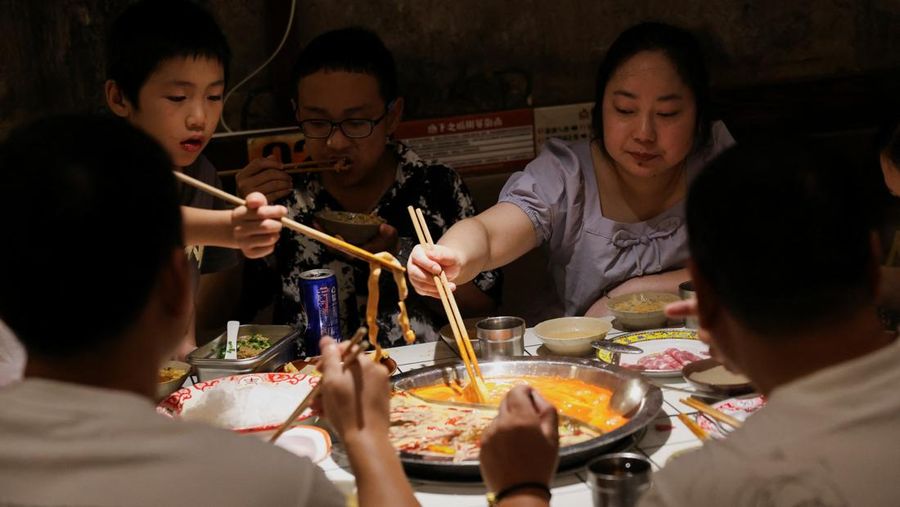 Seorang anak membilas wajahnya dengan air dari pancuran untuk menyejukkan diri di tengah peringatan bahaya panas di Chongqing, Tiongkok, 31 Juli 2025. (REUTERS/Go Nakamura)