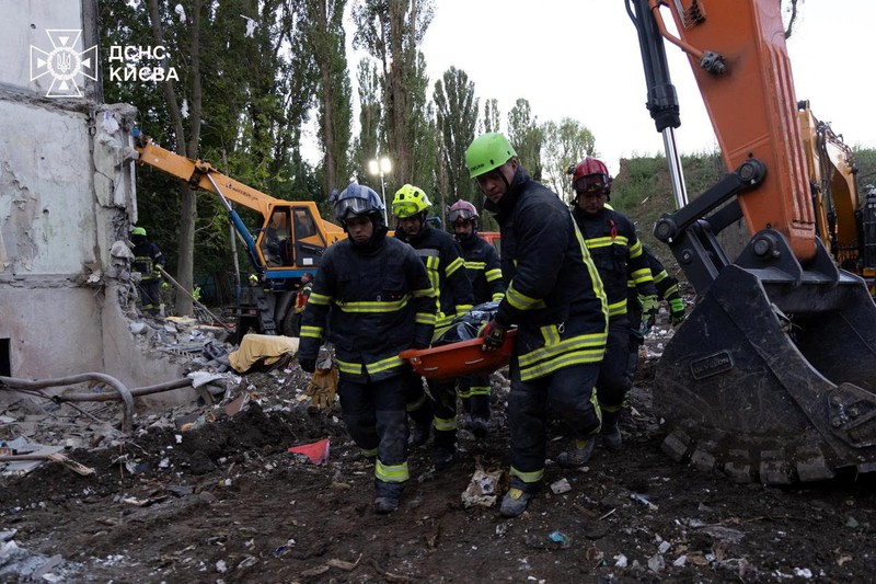 Tim penyelamat bekerja di lokasi sebuah gedung apartemen yang terkena serangan udara Rusia di Kyiv, Ukraina, Jumat (1/8/2025). (Handout via REUTERS)